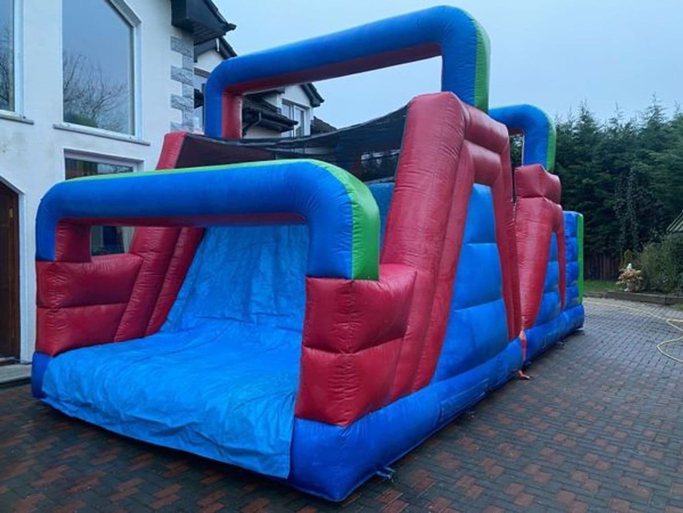 Sea Mint bouncy castle with cool mint pillar turrets and roof canopy, set up near the coast.